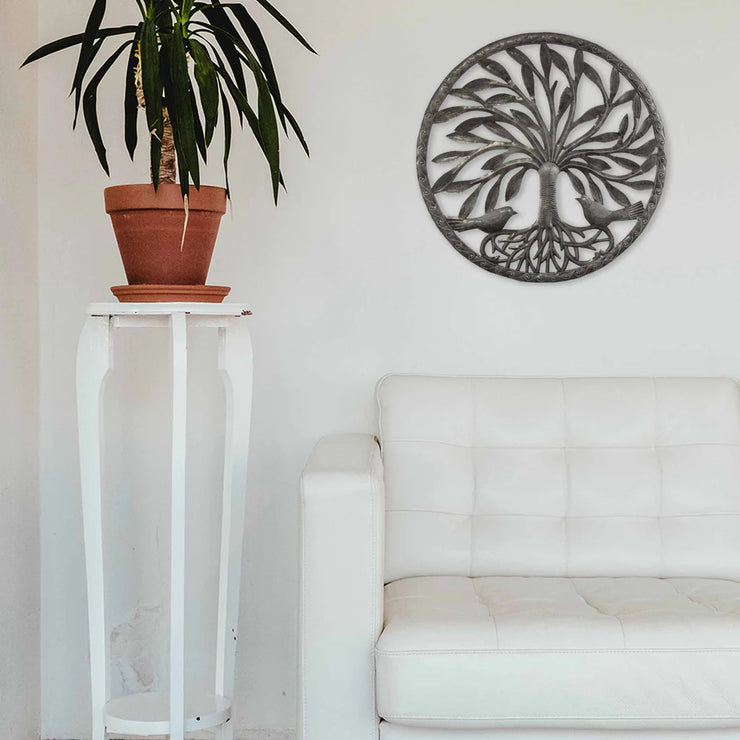 Fair trade Tree of Life wall sculpture in black metal displayed in a modern minimalist living room.