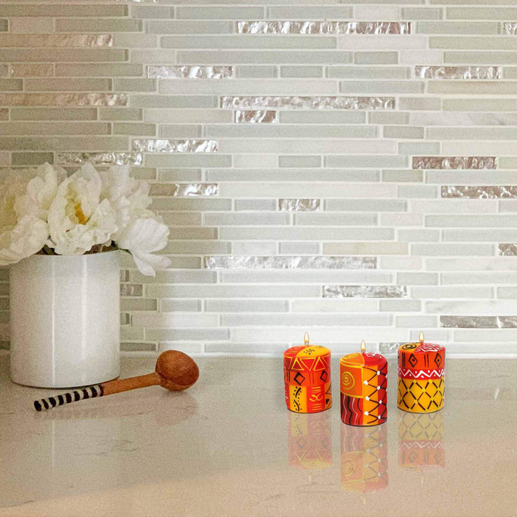 Trio of small artisan candles with colorful Zahabu-style motifs