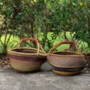 view of two Ghana handwoven Bolga basket, showcasing elephant grass weave and handle that is leather