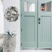 “close-up view of owl faces in Haitian upcycled metal wall sculpture”